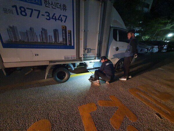 13일 아침 근무를 시작한 택배노동자 김도균(48)씨가 자정을 넘긴 밤 12시30분께 퇴근을 앞두고 방전된 차량 배터리 점검을 받고 있다. 다행히 15분만에 차량 보험사 직원이 현장에 출동했다. 