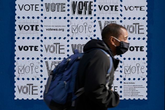 한 시민이 투표 참여 독려 포스터 앞을 지나가고 있다. 시애틀, 워싱턴주. 2020년 10월13일. 