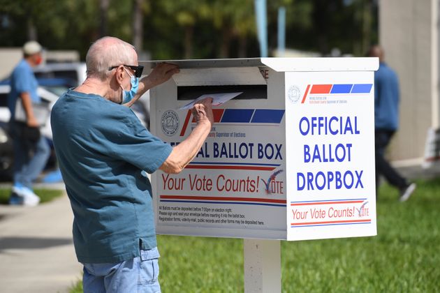 한 유권자가 공식 투표용지 수거함에 우편투표용지를 넣고 있다. 팜비치, 플로리다주. 2020년 10월6일. 