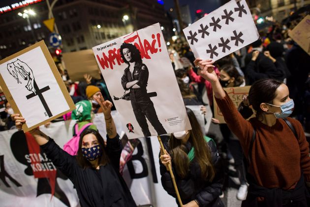 마스크를 쓴 시위자가 시위 도중 폴란드 여성 저항의 상징이 된 시고니 위버의 사진을 들고 있다. 