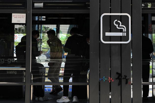 서울 을지로의 한 흡연부스에서 흡연자들이 담배를 피우고 있다.  