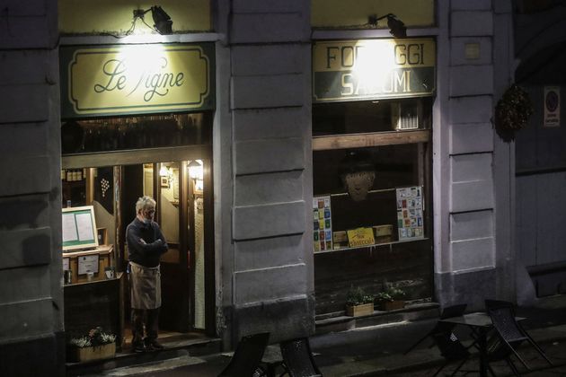 이탈리아 밀라노 네비글리오 그란데 구역에 있는 식당 문간에 식당 주인이 시름에 잠긴 표정으로 서 있다. 2020년 10월 23일, 금요일 밤에 찍은 사진이다.