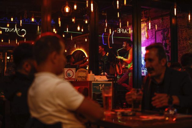 2020년 10월 23일 금요일 밤, 터키 이스탄불의 한 술집에서 뮤지션들이 공연을 하고 있다. 맥주를 마시며 이야기하는 손님들도 보인다.