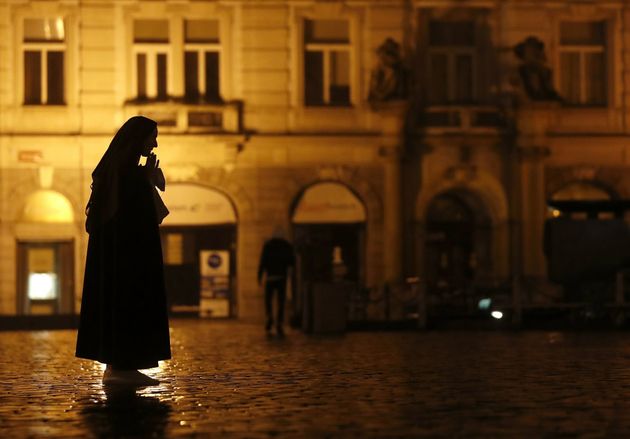 2020년 10월 23일 금요일 밤, 체코 프라하의 텅 빈 구시가지 광장에서 한 수녀가 기도하고 있다.
