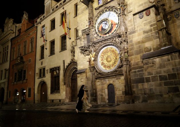 체코 프라하의 텅 빈 구시가지 광장에서 한 수녀가 대형 시계 앞을 지나가고 있다. 역시나 2020년 10월 23일 금요일 밤에 찍은 사진이다.
