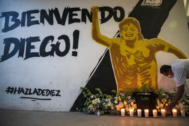 한 남성이 멕시코의 한 지역에 그려진 벽화 앞에서 디에고 마라도나를 추모하고 있다.