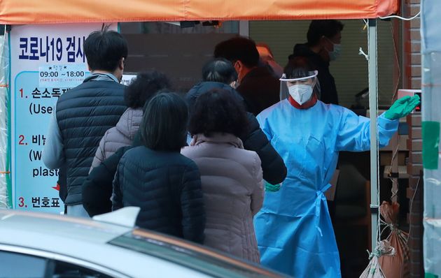 30일 오후 서울 마포구청에 마련된 코로나19 선별진료소에서 의료진이 검사를 받기 위해 방문한 시민을 안내하고 있다.