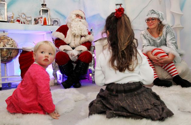 (자료사진) 영국 런던 셀프리지 백화점 안에 마련된 '산타의 동굴'에서 한 어린이가 산타클로스와 이야기를 나누고 있다. 2011년 12월7일.
