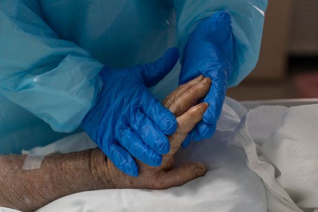 2020년 11월 25일 텍사스주 휴스턴에 있는 유나이티드 메모리얼 메디컬 센터의 코로나19 중환자실에서 의료진이 코로나19로 고통받는 환자의 손을 부드럽게 마사지하고 있다.
