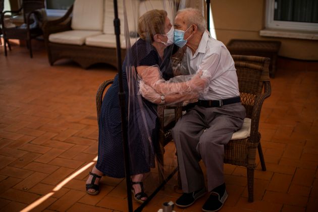 아우구스티나 카나메로(81)씨와 파스쿠알 페레스(84)씨가 코로나19 감염을 막기 위해 설치된 비닐을 사이에 두고 입을 맞추고 있다. 바르셀로나, 스페인. 2020년 6월22일.