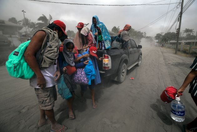 탈(Taal) 화산이 폭발해 화산재가 하늘을 뒤덮은 가운데 한 가족이 대피하고 있다. 레메리, 바탕가스주, 필리핀. 2020년 1월13일. 