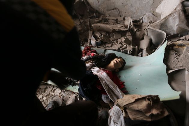 긴급구호활동가들이 정부군의 공습으로 붕괴된 건물 잔해 더미에서 한 소년의 시신을 수습하고 있다. 이들리브, 시리아. 2020년 2월11일.