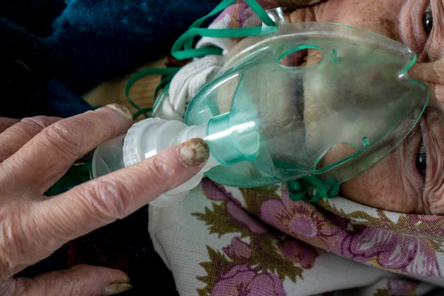 코로나19에 감염된 한 노인이 산소마스크의 도움으로 힘겹게 숨을 쉬고 있다. 포차이우, 우크라이나.
