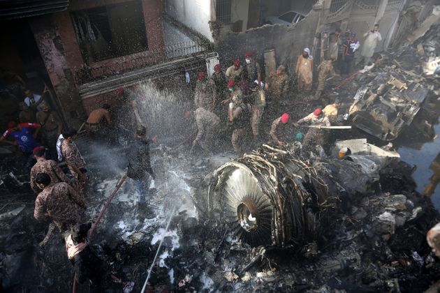 100명 넘는 승객을 태운 채 주택가에 추락한 여객기의 잔해 속에서 수색작업을 벌이고 있는 구급대원들. 카라치, 파키스탄. 2020년 5월22일.