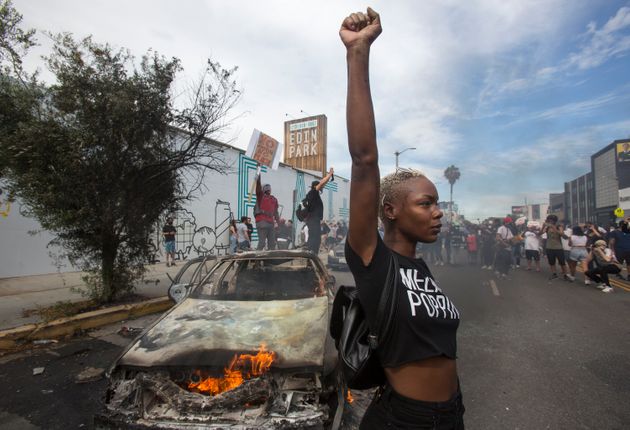 미국 전역을 뒤덮은 '블랙 라이브스 매터' 시위에서 한 시위자가 불에 탄 경찰차 앞에서 주먹을 치켜들고 있다. 로스앤젤레스, 캘리포니아주, 미국. 2020년 5월30일. 