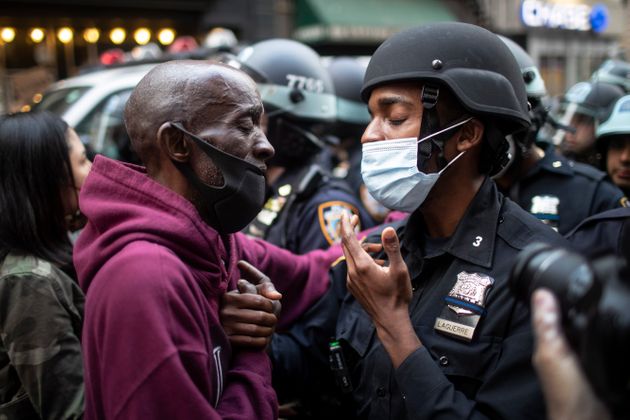 미국 뉴욕에서 열린 '블랙 라이브스 매터' 시위 도중 한 시위자와 경찰이 화해의 제스처를 취하고 있다. 2020년 5월25일.