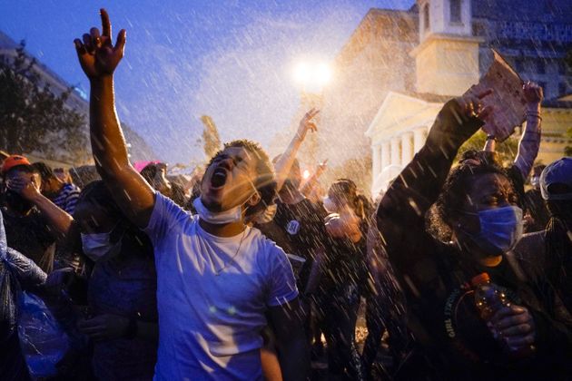 조지 플로이드의 사망에 항의하는 시위대가 백악관 앞에서 비를 맞으며 구호를 외치고 있다. 2020년 6월4일.