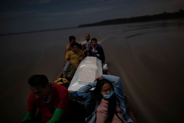 페루에서 코로나19 합병증으로 사망한 호세 바바란씨의 시신이 담긴 관을 친척들이 보트에 실어 옮기고 있다. 이들은 고인을 고향 땅에 묻기 위해 4시간 동안 배를 타고 강을 따라 이동했다. 2020년 9월29일. 