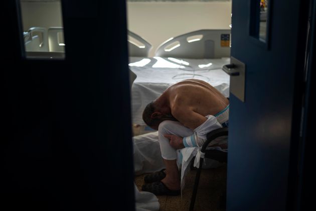 병원에 입원 중인 한 코로나19 환자가 침대 옆 의자에 앉아 고개를 파묻고 있다. 바르셀로나, 스페인. 2020년 11월18일.