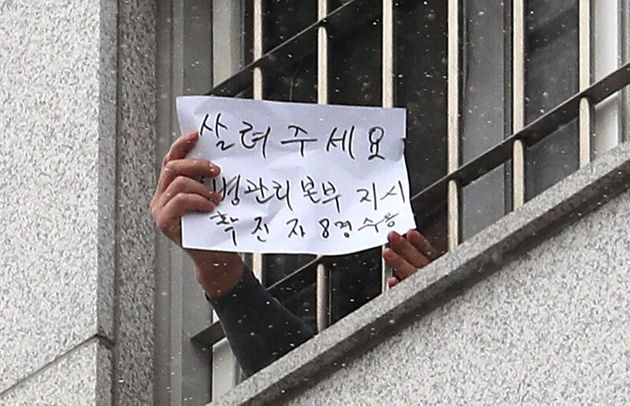 대규모 집단감염이 발생한 서울 동부구치소에서 233명이 추가 확진되면서 누적 확진자가 761명으로 집계된 29일 서울 송파구 동부구치소에서 한 수용자가 자필로 '살려주세요'라고 쓴 문구를 취재진에게 보여주고 있다. 