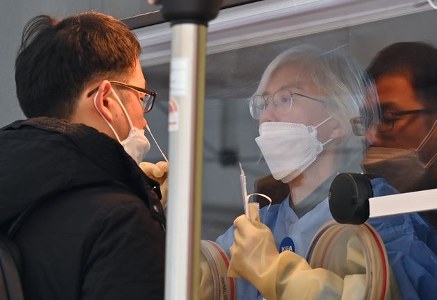2020년 12월 23일 서울시청 외부의 선별진료소에서 의료진이 코로나19 검사를 하고 있다. 