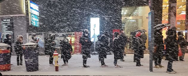 6일 저녁 서울 강남역 인근에서 시민들이 눈발을 맞으며 버스를 기다리고 있다. 