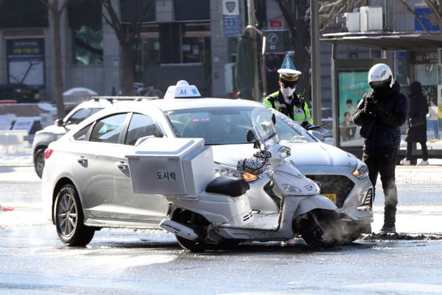7일 서울 광화문 사거리에서 배달 노동자가 교통사고가 나 사고를 처리하고 있다.