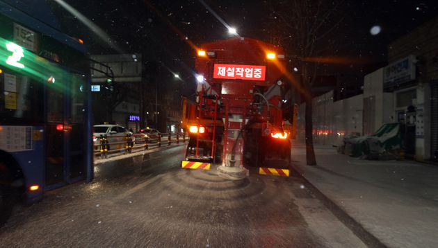 전국 곳곳에 대설 특보가 발효중인 17일 저녁 눈이 내린 서울 동작구 장승배기역 인근 상도로에서 제설 차량이 도로에 염화칼슘을 뿌리며 이동하고 있다.  