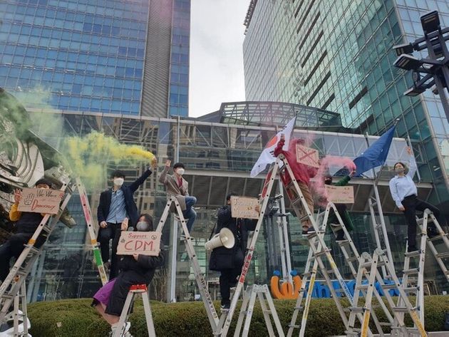 서울 강남구 포스코센터 앞에서 시민단체들이 사다리 위에 올라가 연막탄을 터뜨리며 “포스코는 반성하고 미얀마에 사과하라”고 구호를 외치고 있다. 전광준 기자