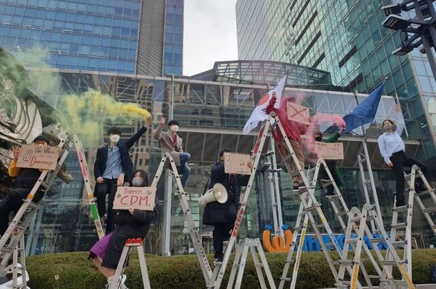 서울 강남구 포스코센터 앞에서 시민단체들이 사다리 위에 올라가 연막탄을 터뜨리며 “포스코는 반성하고 미얀마에 사과하라”고 구호를 외치고 있다.