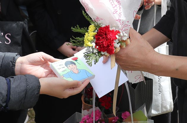故 손정민 군의 아버지 손현씨가 어버이날인 8일 오후 서울 서초구 반포한강공원 택시승강장 앞에서 응원 온 시민들에게 카네이션과 손정민 군의 그림을 받고 있다.