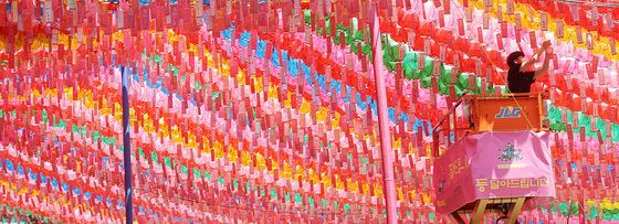 부처님 오신날을 하루 앞둔 5월 18일 서울 종로구 조계사에서 관계자가 연등에 소원지를 매달고 있다.