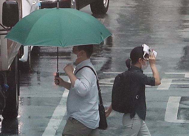 소나기가 쏟아진 23일 오후 서울 종로구 정부서울청사 인근 횡단보도에서 시민들이 걸음을 재촉하고 있다. 2021.6.23