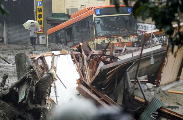 2021년 7월 3일 일본 아타미 이즈산 지구에 내린 폭우에 따른 산사태 현장에서 파손된 버스와 주택 잔해들이 보이고 있다.
