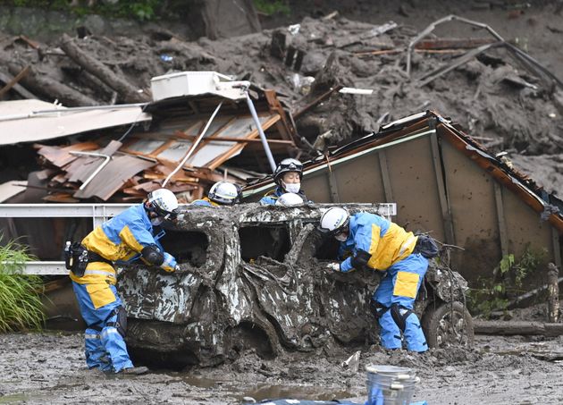2021년 7월 4일 일본 도쿄 서부 아타미 이즈산지구에서 폭우로 파괴된 차량 주변에서 경찰이 수색구조 작업을 벌이고 있다.