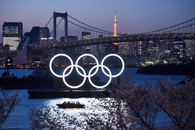 2020년 3월 25일 일본 도쿄에서 보트 한 척이 도쿄 2020 올림픽 링을 지나 항해하고 있다.