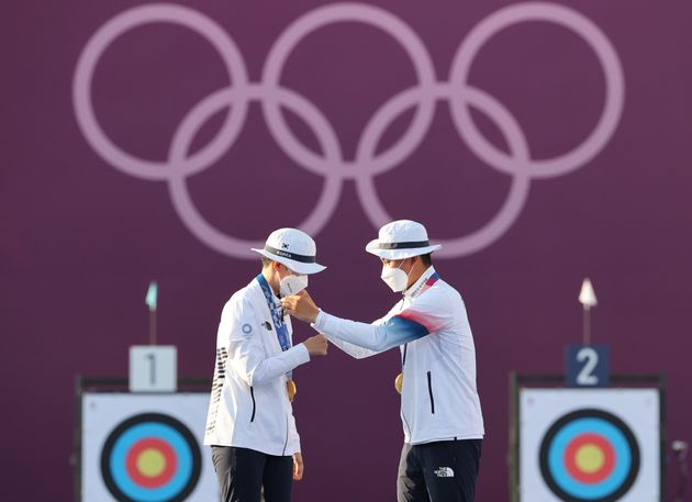 서로의 목에 금메달을 걸어주는 대한민국 양궁대표팀 안산과 김제덕.