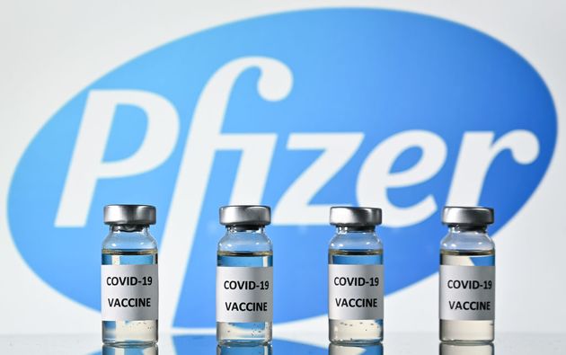 2020년 11월 17일 코로나19 백신 스티커가 부착된 병 뒤로 미국 제약회사 화이자(Pfizer)의 로고가 보인다.