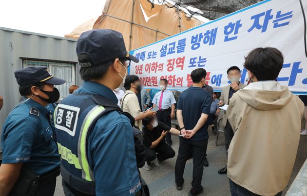 1일 오전 서울 성북구 사랑제일교회 앞에서 경찰이 교회 관계자들과 대면예배 중단과 관련해 이야기하고 있다.