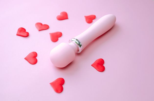 Pink sex toy vibrator for women over pink background.