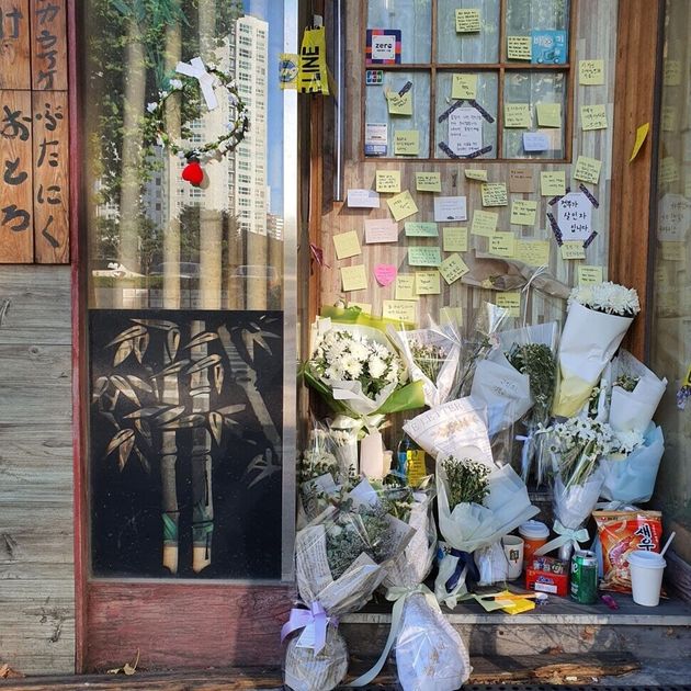 지난 7일 숨진 채 발견된 자영업자 ㄱ(57)씨가 운영하던 서울 마포구의 맥줏집 문 앞에 17일 오후 ㄱ씨를 추모하는 포스트잇과 조화가 놓여 있다. 정유경 기자 edge@hani.co.kr