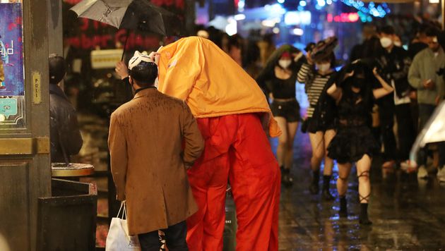 핼러윈데이인 31일 오후 서울 용산구 이태원을 찾은 시민들이 갑자기 쏟아지는 비를 피해 발걸음을 움직이고 있다
