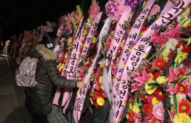 박근혜 전 대통령의 특별사면을 하루 앞둔 30일 오후 한 지지자가 서울 강남구 삼성서울병원 앞에 박 전 대통령의 사면을 축하하는 화환을 정리하고 있다.