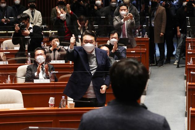 윤석열 국민의힘 대선 후보가 6일 국회에서 열린 의원총회에서 이준석 대표의 발언에 일어나 엄지를 치켜 올리고 있다.