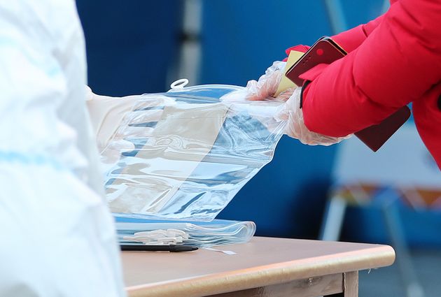 5일 서울역 남영동 사전투표에서 확진자 및 격리자들이 투표 후 투표지를 비닐팩에 담고 있다. 