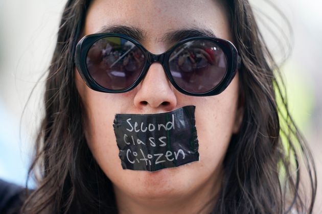 '이등 시민' 이라 적힌 테이프를 입에 붙인 여성.