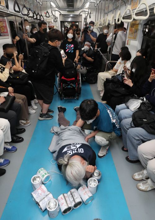 박경석 전장연 상임공동대표와 활동가들이 장애인 권리예산과 이동권 보장을 촉구하며 삼각지역에서 지하철을 타고 회현역에 도착해 내리고 있다. (2022.6.2)