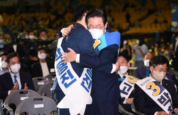 이재명 더불어민주당 신임 당 대표가 28일  28일 서울 송파구 올림픽 체조경기장에서 열린 제5차 정기전국대의원대회에서 당 대표로 선출된 뒤 박용진 후보와 포옹하고 있다. 출처: 공동취재사진