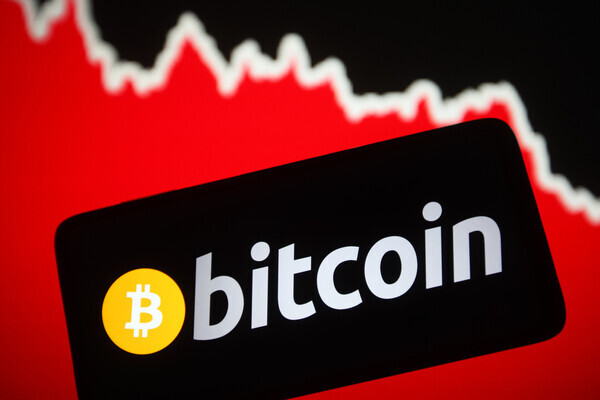 UKRAINE - 2022/01/23: In this photo illustration, a Bitcoin cryptocurrency sign is seen on a smartphone screen and a graphic in the background. Bitcoin falls to $35 150. (Photo Illustration by Pavlo Gonchar/SOPA Images/LightRocket via Getty Images)