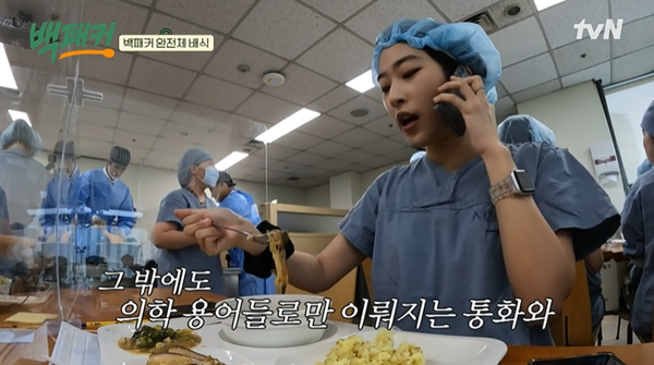 밥을 먹으며 전화기를 내려놓지 못하는 의료진.&nbsp;출처: '백패커' 네이버 TV